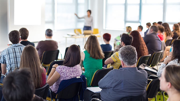 Students at desks listening to teacher